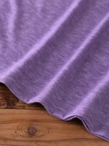 Purple cotton blend solid t-shirt detail showing soft heather fabric texture and fine hem stitching.