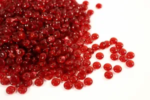 Primo piano di perline distanziatrici piatte rosso scuro, ideale per la gioielleria fai da te.
