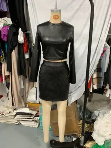 Black faux leather two-piece set featuring long sleeve crop top and fitted mini skirt outfit.