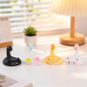 Cute cat phone stand detail, creative desktop decoration holder, cozy room setup view.