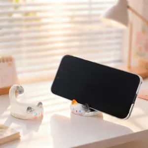 Cute cat phone holder detailed view, ceramic desktop ornament for watching videos.