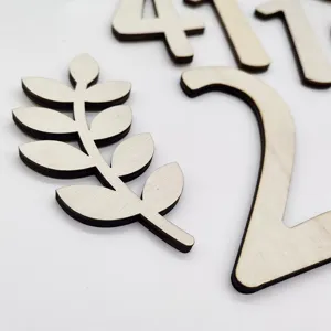 Dettaglio di numeri e foglie in legno intagliato, perfetti accessori per foto e decoro.