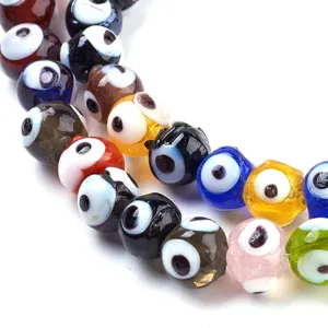 Primer plano detalle de cuentas de vidrio de colores artesanales motivo ojo para joyería.