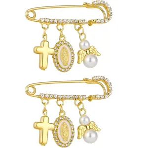 Gros plan détail de broche épingle de sûreté dorée vintage avec strass, croix et perle.