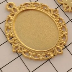 Close-up detail of vintage gold alloy oval bezel tray pendant, perfect for DIY crafting.