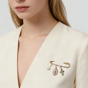 Gros plan d'une broche épingle de sûreté vintage élégante avec perle et pendentifs.