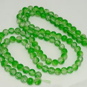 Green crackle glass beads detail close up, shiny round crystal loose beads for DIY craft jewelry.