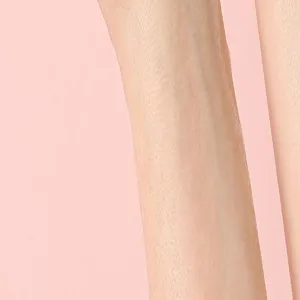Primo piano dettagliato della pelle liscia delle gambe o di una fine trama di calze su sfondo rosa.