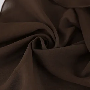 Close-up detail shot of dark brown textured fabric with soft drapes and elegant look.