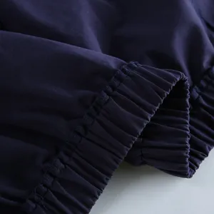 Donkerblauwe jas manchet detail, elastische geplooide zoom, casual kleding dichtbij.