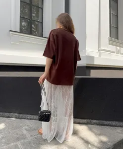 Vista dettagliata della gonna lunga bianca in pizzo trasparente, elegante e alla moda.