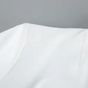 White women blazer shoulder detail, clean cut tailored suit jacket fabric close-up view.