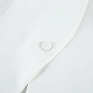 Close-up view of elegant white women's blazer fabric and matching covered button detail.