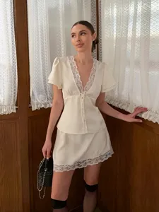 Chic satin lace two-piece set featuring short sleeve v-neck tie top and matching mini skirt.