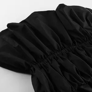 Nahaufnahme des schwarzen trägerlosen Plissee-Tops mit strukturierter Raffung an der Taille.