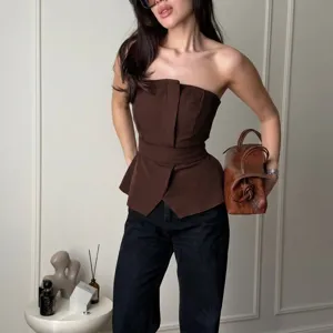 Detail shot of a stylish brown strapless peplum corset top featuring a waist tie design.