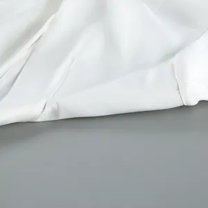 White blazer fabric detail showing fine stitching and smooth texture for women apparel.