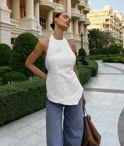 Stylish white halter neck backless sleeveless top perfectly paired with casual blue jeans.
