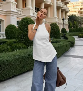 Detail shot of a chic white halter neck backless sleeveless top, stylish summer fashion look.