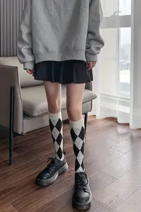 Detailed view of black and white argyle pattern knee high socks showcasing classic knit style.
