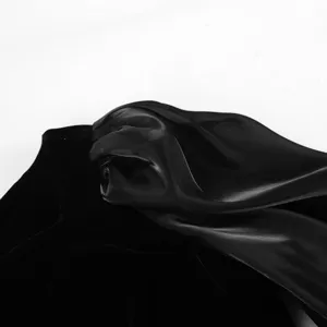 Detalle de tela de vestido de terciopelo negro, elegante textura de cuello y manga cerca.