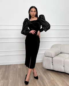 Vestido midi ajustado de terciopelo negro con cuello cuadrado y mangas abullonadas.