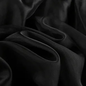 Black satin fabric texture detail close up view for elegant fashion apparel design.