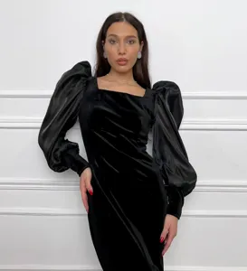 Vista detallada del vestido midi negro de terciopelo con escote cuadrado y mangas abullonadas.