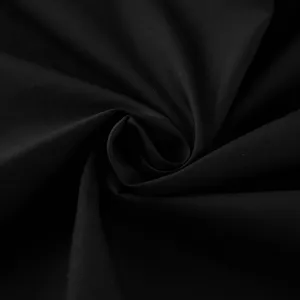 Primo piano dettaglio tessuto cotone nero, texture premium per design gonna irregolare.