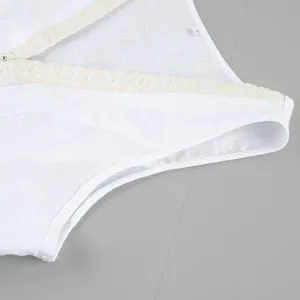 Detailansicht des weißen ärmellosen Baumwolltops mit feiner Spitzenborte am eleganten V-Ausschnitt.