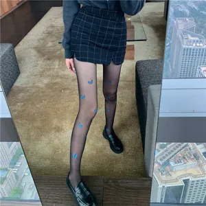 Detail shot of women black sheer pantyhose with blue butterfly print, fashion leg wear.