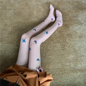 Sheer tights featuring delicate blue butterfly print, close-up view showing leg detail and soft fabric.