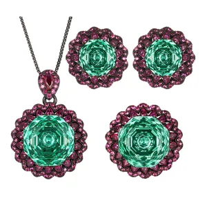 Detaillierte Ansicht des luxuriösen Schmucksets in Schwarzgold mit grünen und pinken Steinen.
