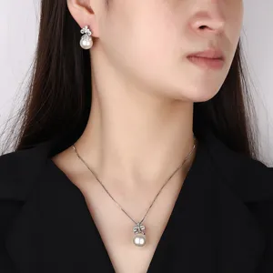Vista dettagliata del set di collana e orecchini di perle con brillanti motivi floreali.