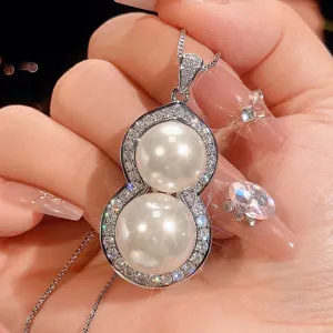 Close-up detail of a double-pearl gourd pendant necklace with sparkling zircon pavé setting.