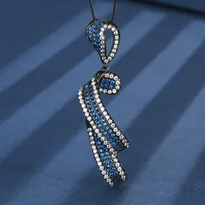 Collier pendentif ruban plaqué or noir, vue rapprochée de pierres bleues et blanches.