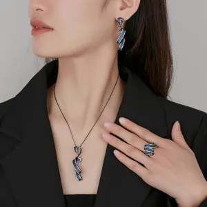Detail de parure de bijoux en or noir spinel bleu avec collier boucles bague sur modele.