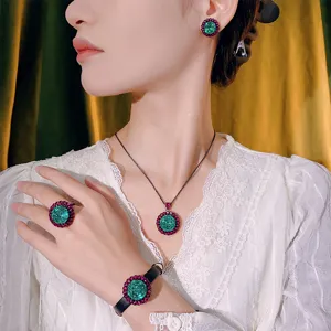 Elegant black gold jewelry set with green and red cluster stones, necklace ring earrings.