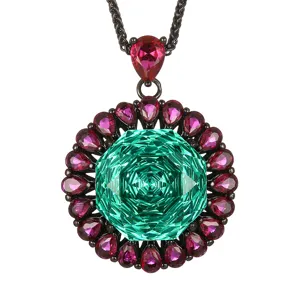 Elegant black gold-plated necklace featuring large green central gemstone with pink crystal halo.