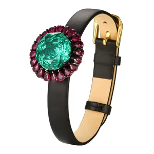 Luxury black leather bracelet featuring a large green gemstone and pink crystal halo.