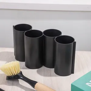 Detail view of black four-compartment kitchen utensil holder and chopstick drainer.