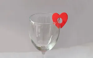 Close-up detail view of a vibrant red heart silicone wine glass charm marker on rim.