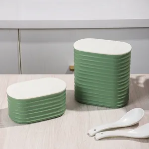 Green ribbed plastic storage jars with white lids and spoons for kitchen organization detail view