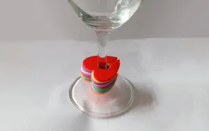 Detailed close-up of colorful silicone heart wine glass markers stacked on the stem.