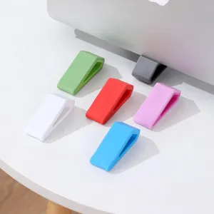 Colorful silicone trapezoidal laptop stands set on a white desktop for cooling and ergonomic riser use.
