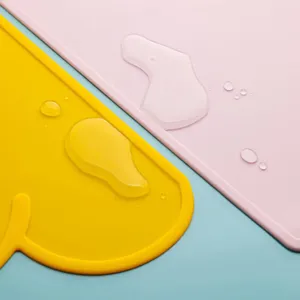 Silicone cloud placemat detail view, waterproof baby dining mat in bright yellow and pink colors.
