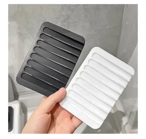 Silicone soap dish with draining slots, anti-slip bathroom tray holder in black and white.