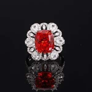 Splendido anello cocktail con pietra rossa e luminoso alone floreale in zircone lucido.