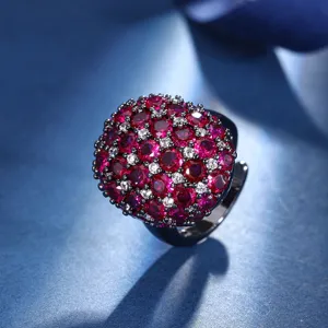 Stunning black gold plated domed ring featuring a vibrant cluster of red and white simulated gemstones.