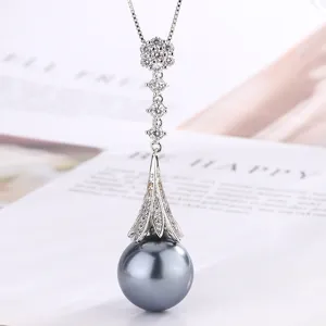 Detailed shot of a shimmering cubic zirconia tassel black pearl pendant necklace.